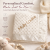 Cream-colored minky baby blanket with a raised dot texture and silky satin trim, featuring the name embroidered in tan, diagonally positioned across the fabric.





