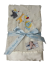 Soft cream Luxe Bella baby blanket with satin trim, featuring adorable embroidered party animals—lion, giraffe, and elephant with balloons.