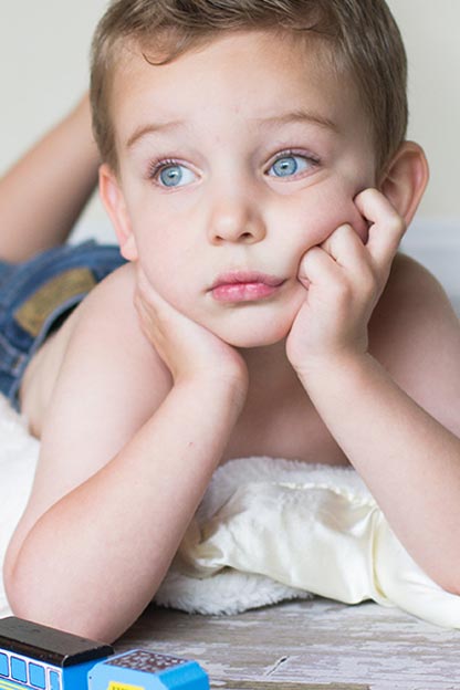 Young boy laying on a blanket